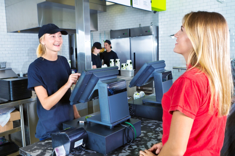 female minimum wage employee at fast food restaurant serving woman in red shirt