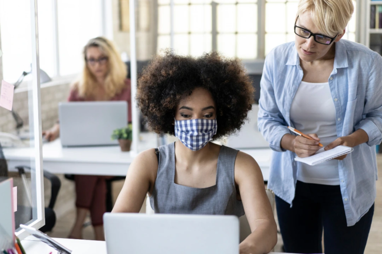 employee wearing mask at work while other employees are not - image portraying information included in the EEOC's updated COVID-19 guidance.