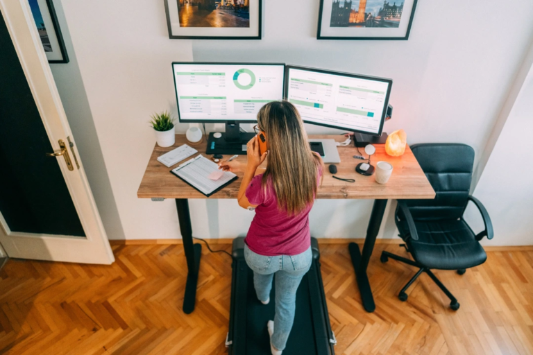 woman working at standup desk at home office for a blog post on home office reimbursement