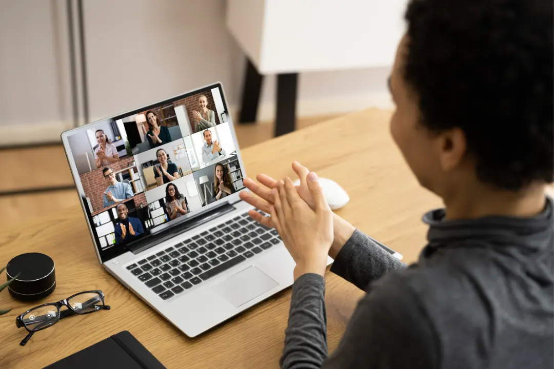 Remote employees clapping during virtual meeting showing remote appreciation.