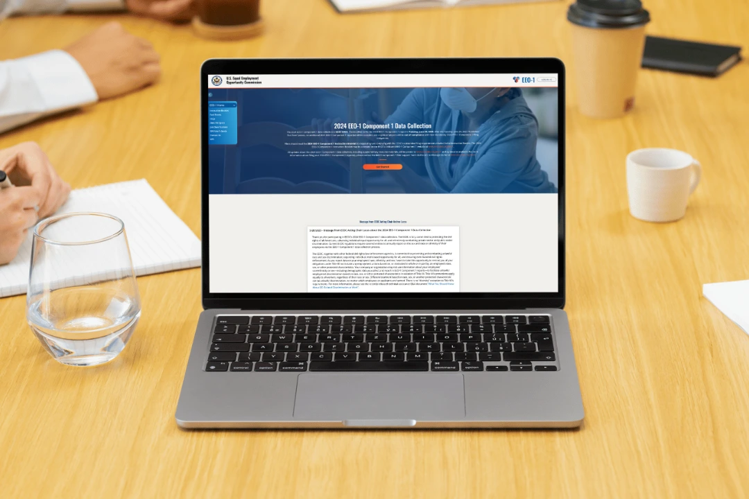 Laptop screen showing the EEOC’s 2024 EEO-1 Reporting portal open during a workplace meeting.