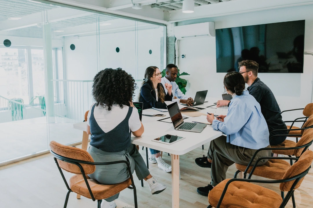 Professionals in a modern office meeting to discuss how to engage and retain talent through collaboration, culture, and employee support.